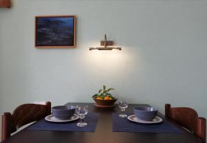 维甘Apartments Kuća Nebeska的餐桌,带两个盘子和酒杯