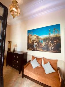 马拉喀什Riad Ajmal的客厅配有沙发和墙上的绘画