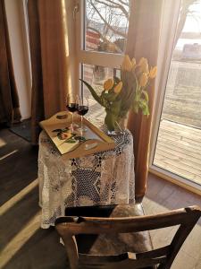 MelhusStrandheimen Guesthouse的花瓶和两杯葡萄酒的桌子