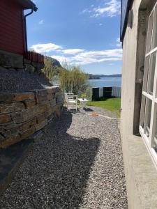 卑尔根Koselig nyoppusset 3 roms leilighet med egen parkeringsplass i rolige omgivelse nær sjøen, 2 mil nord for Bergen sentrum.的水景建筑旁边的石墙