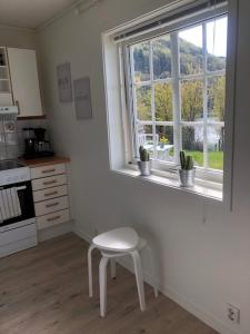卑尔根Koselig nyoppusset 3 roms leilighet med egen parkeringsplass i rolige omgivelse nær sjøen, 2 mil nord for Bergen sentrum.的厨房配有白色的凳子和窗户