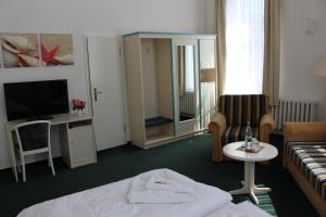 奥斯特西巴德钦诺维茨Baltisches Haus Pension Moll的酒店客房配有床、沙发和电视。