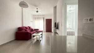 圣胡安德洛斯特雷罗斯Apartamento con piscina, San Juan de los Terreros的客厅配有红色的沙发和桌子
