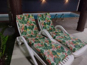 若昂佩索阿Casa encantadora com piscina prainha e SPA的游泳池旁的一把椅子