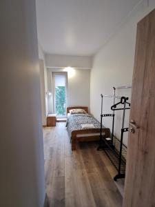 乌田纳Viešbutis Kelyje的一间卧室配有一张床,铺有木地板