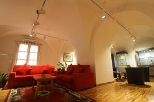 杰拉切Albergo Palazzo Sant'Anna的客厅配有两张红色的沙发和一张桌子
