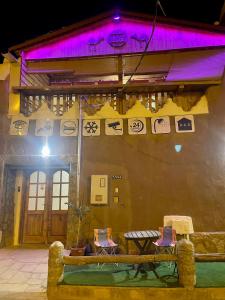 Shaqraنُزُل تُراثي شقْراء Heritage Guesthouse Shaqra的建筑的侧面有紫色的灯