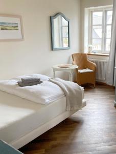 博恩Pension Walfischhaus的白色卧室配有床和椅子