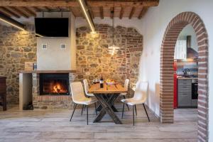 福洛尼卡Residenza Castello di Valli的厨房以及带桌子和壁炉的用餐室。