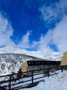 BrañaviejaApartamento en estación de esquí y montaña alto campoo的雪中的一个火车站,背景是群山