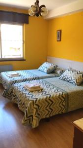 卡瑞纳Pensión Casa Corro的黄色墙壁客房的两张床