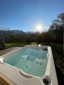 尚普索地区圣博内"Le Cottage" Appartements avec SPA privatif的庭院内的按摩浴缸,背面是太阳