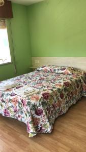 卡瑞纳Pensión Casa Corro的绿色客房内的一张床位,配有花卉床罩