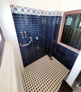 乔治市东印度群岛大厦旅馆的带淋浴的浴室和蓝色瓷砖墙壁