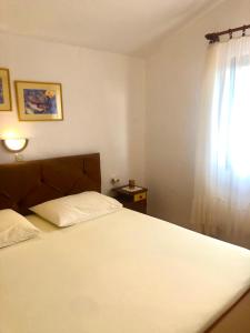 苏佩塔斯卡德拉加Apartmani Anamar的卧室配有白色的床和窗户。