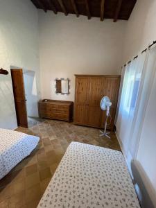 拉莫拉Can Joan Barber, 2的一间卧室配有一张床、木制橱柜和风扇。