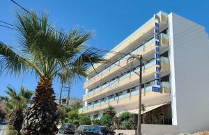 海若克利欧阿西恩尼克酒店的一座建筑前的棕榈树