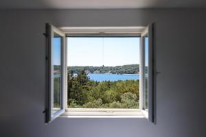 VerunićApartments Marta的湖景开放式窗户