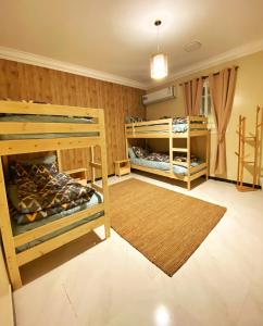 艾卜哈Bohemian style的一间设有两张双层床和地毯的房间