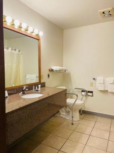 桑德波因特America's Best Value Inn的一间带卫生间、水槽和镜子的浴室
