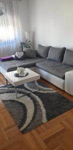 萨格勒布Apartman Aura的带沙发和咖啡桌的客厅