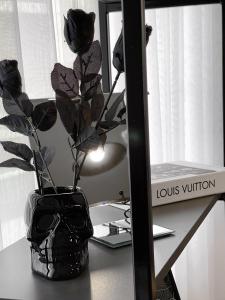 普里什蒂纳Pristina City Apartment的花瓶,坐在镜子旁的桌子上