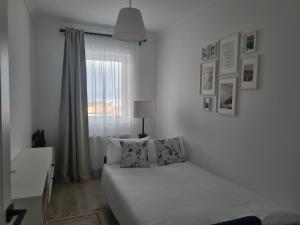 泽尔内什蒂Apartament Crai的白色的卧室设有床和窗户