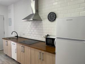塔里法Apartamento Tarifa Sunset的厨房配有冰箱和墙上的时钟