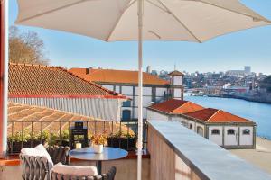 波尔图Wonderful Porto Design Apartments的阳台配有桌子和雨伞。