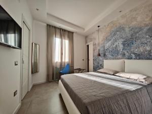 马达莱纳Capricci di Vento - Design Guest House的一间卧室配有一张大床和一张蓝色椅子