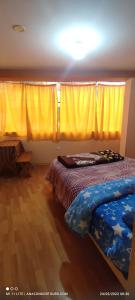 库斯科Anacondor Guests House的一间卧室设有两张床和黄色窗帘
