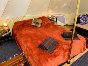 加伯维尔Glamping in the Redwoods的帐篷,配有两顶帽子和床上的毛巾