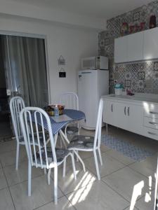 坎波斯杜若尔当Residencial Recanto Genebra - Campos do Jordão的厨房配有桌椅和冰箱。