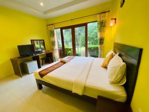 三百岭华欣普兰曼内海滩度假村的一间卧室设有一张黄色墙壁的大床