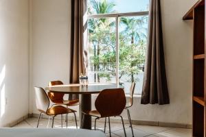 巴亚尔塔港Loft Hotel Malecón Vallarta的一间带桌椅和窗户的用餐室