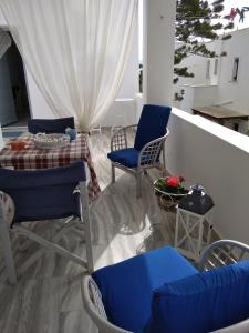 克里希阿克提Kiki's apartment huge balcony dream的阳台配有蓝色的椅子、桌子和桌子