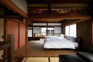 京都Umeyu no yado by YADORU KYOTO HANARE的一间卧室配有一张带白色床单的大床