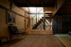 京都Umeyu no yado by YADORU KYOTO HANARE的一间带楼梯和椅子的客厅