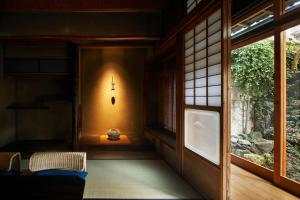 京都Umeyu no yado by YADORU KYOTO HANARE的窗户旁的墙上有十字架的房间