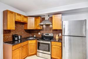 费城Spacious 1BD Apt in the heart of City的厨房配有木制橱柜和不锈钢冰箱。