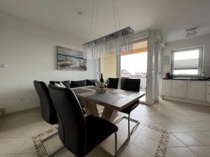 波雷奇Maj Premium Apartment 4 Sterne - neu renoviert的用餐室配有木桌和黑椅子