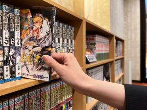 京都Rinn Gion Yasaka的一个人正在书架上找一本漫画书