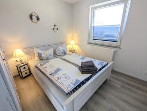 奥斯赛拜-塞林Ferienhaus Sellin的卧室配有白色的床和窗户