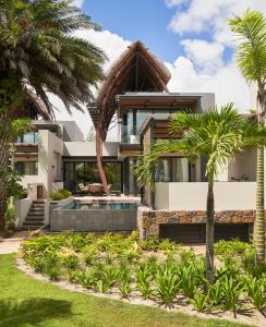 格兰贝伊LUX* Grand Baie Resort & Residences的一座带游泳池和棕榈树的房子