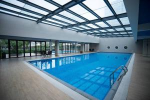 下龙湾*Ha Long Homestay @ Sunrise Apartment- 4 BR的大型游泳池设有大型玻璃天花板