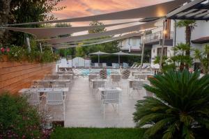 马尔米堡塔拉贝拉酒店的一个带桌椅的庭院和一个游泳池