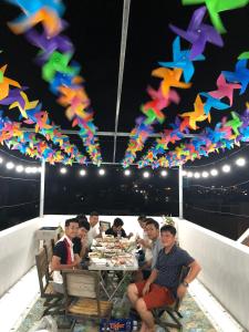 头顿Thảo Nguyên Hotel的一群人坐在桌子上,放着五颜六色的风筝