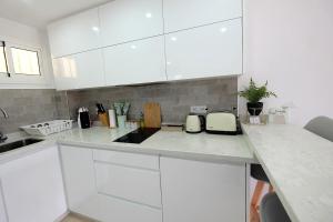 贝纳尔马德纳Benalmadena Jupiter - SunSea Apartments的白色的厨房配有白色的橱柜和台面