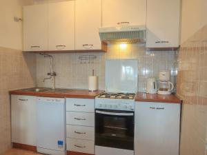 科尔尼奇Holiday Home Mateja - KRK228 by Interhome的厨房配有白色橱柜和炉灶烤箱。