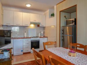 科尔尼奇Holiday Home Mateja - KRK228 by Interhome的一间带桌子的厨房和一间带白色家电的厨房